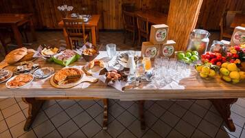 Une table à manger dressée avec divers plats, assiettes et verres, dans un décor intérieur en bois.