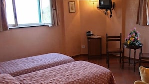 A hotel room with two beds, a small table, a chair, a TV, and a flower vase. - Villa Romita (Massa Lubrense)