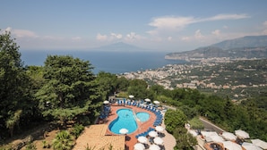 A resort with a pool, sun loungers, and a view of the sea and mountains. - Villa Romita (Massa Lubrense)