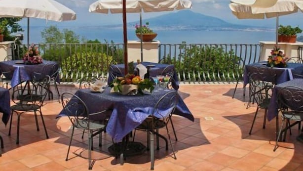 An outdoor terrace with tables and chairs, covered by umbrellas, overlooking a scenic view. - Villa Romita (Massa Lubrense)