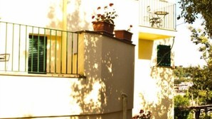 A building with balconies, windows with shutters, and potted plants. - Villa Romita (Massa Lubrense)