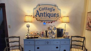 A vintage-style dresser with drawers and a sign above it that reads "Cottage Antiques". - Applesauce Inn B&B (Bellaire)