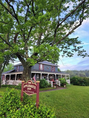 A large tree in front of a house with a sign that reads "Applesauce Inn Bed & Breakfast". - Applesauce Inn B&B (Bellaire)