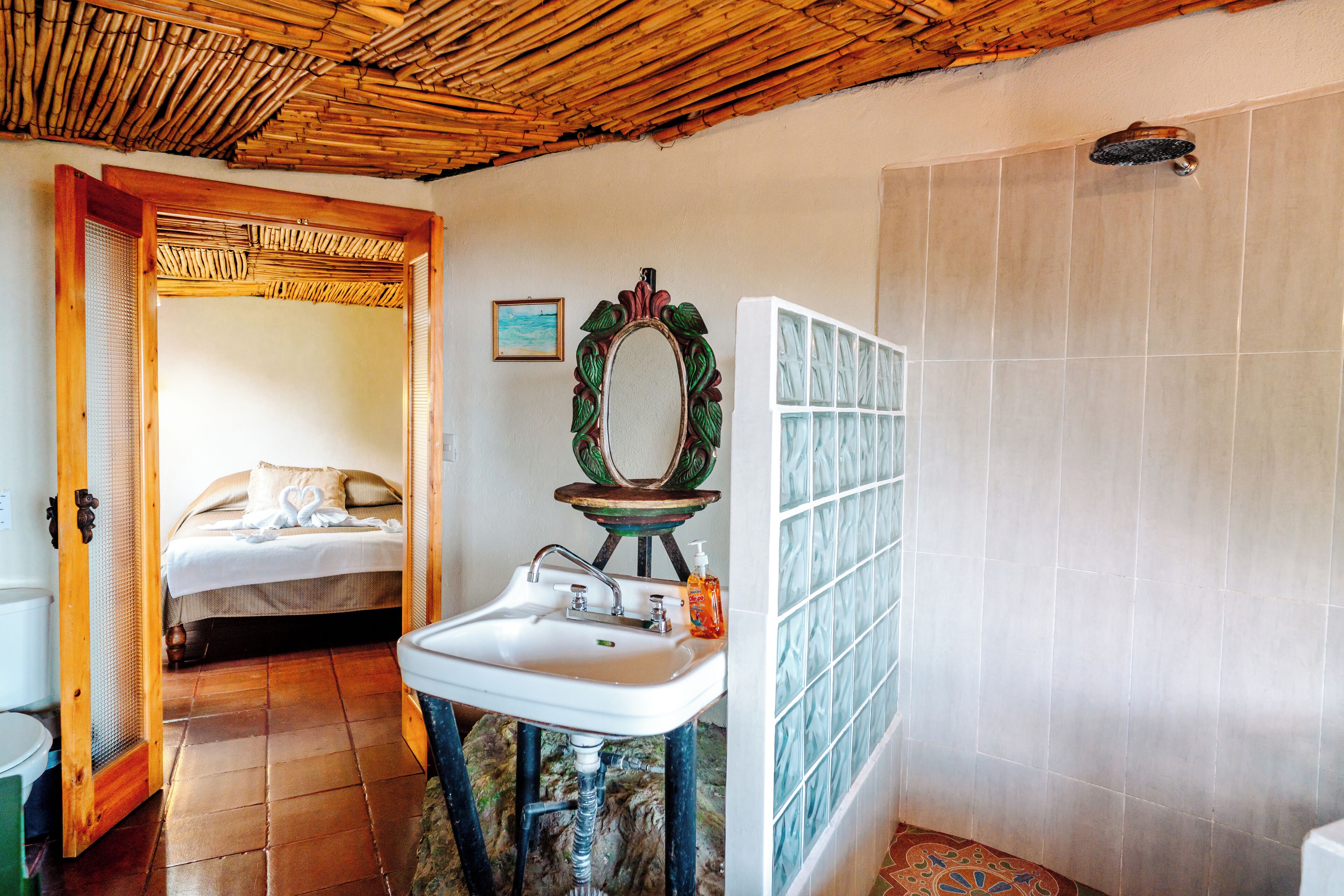 A bathroom with a sink, mirror, and shower.