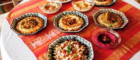 Una mesa con diversos platos sobre un mantel a rayas.