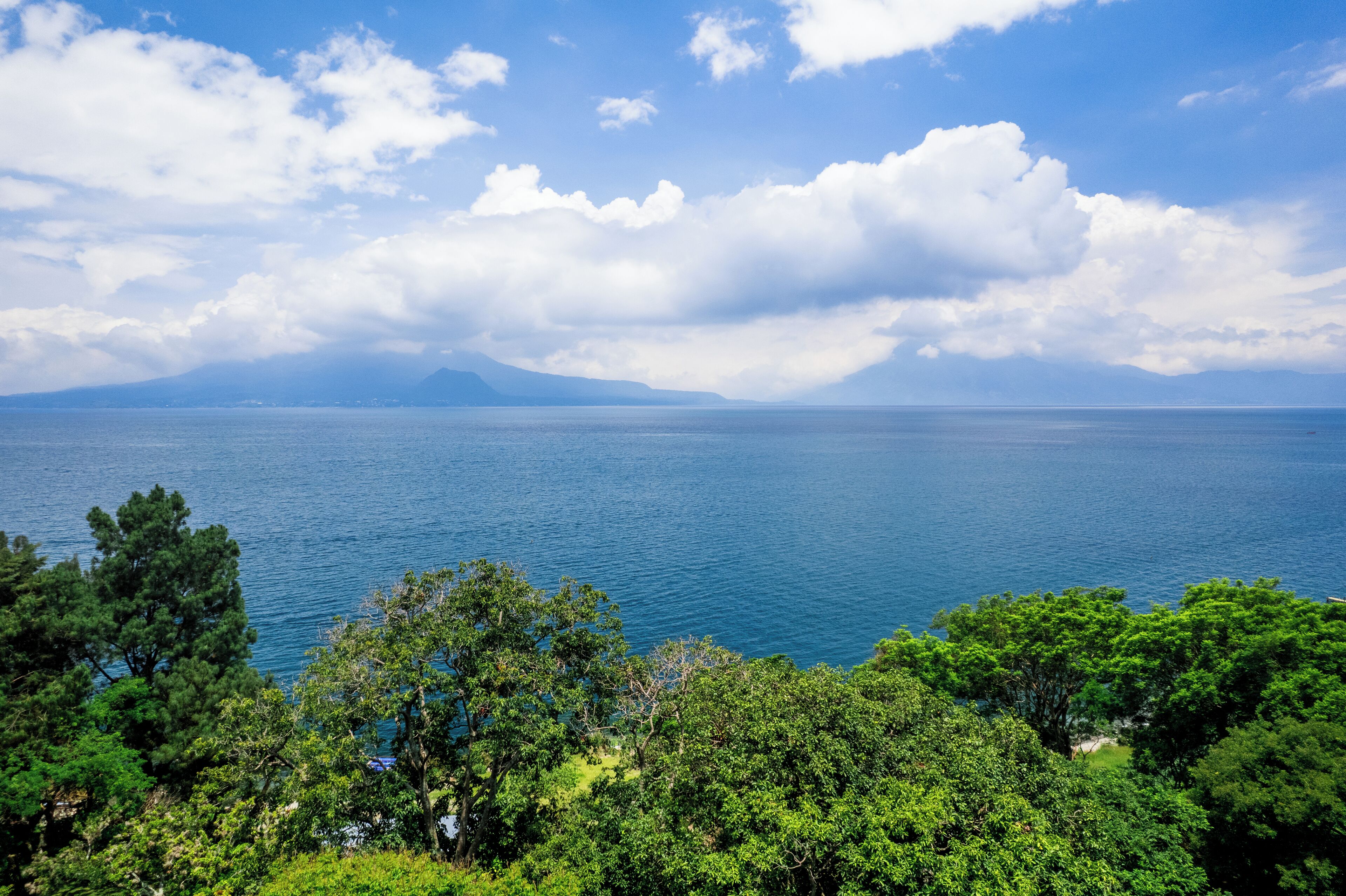 A coastal landscape with a view of the sea and distant mountains.