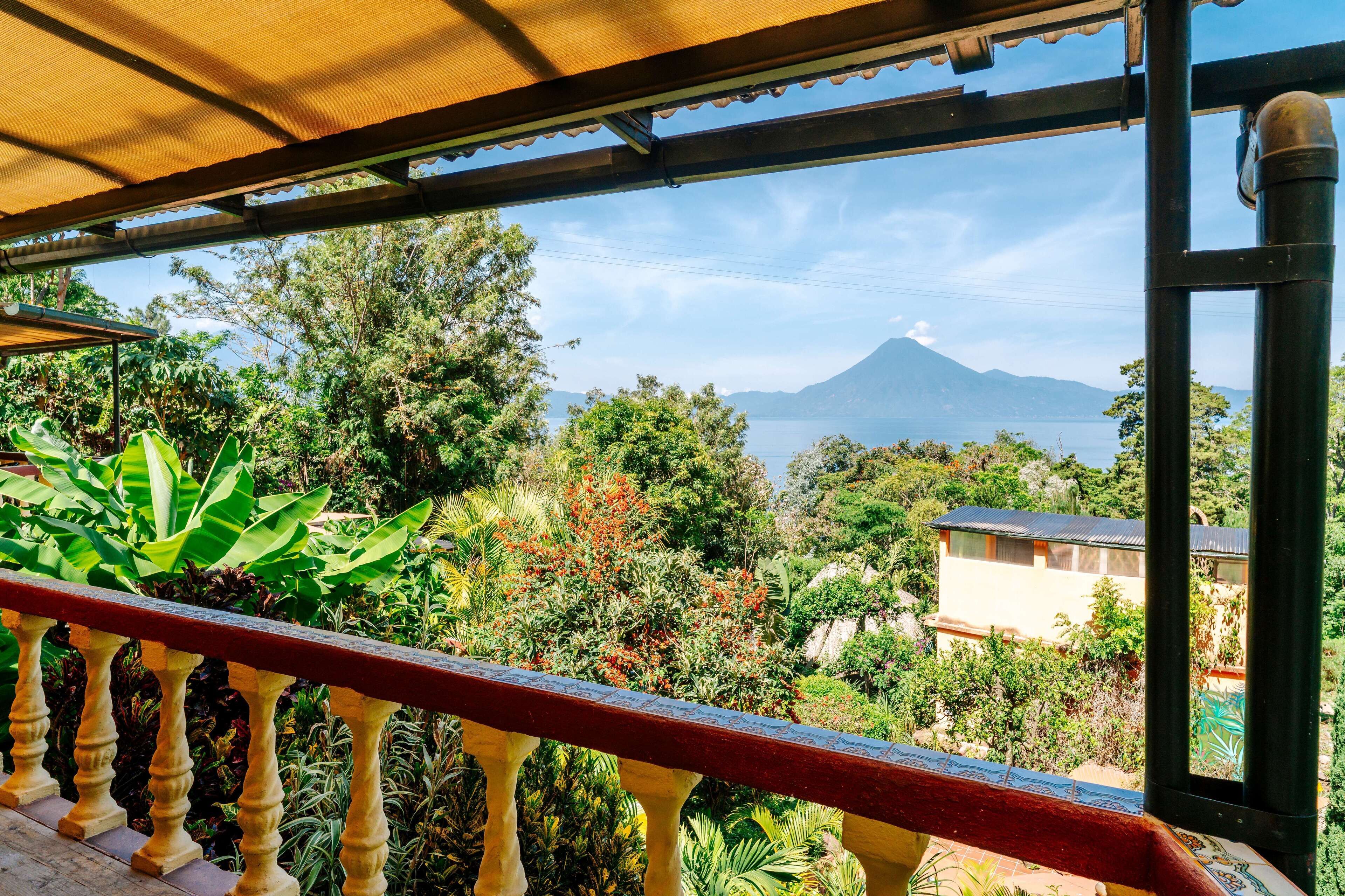 A balcony with a view of a mountain and a body of water.