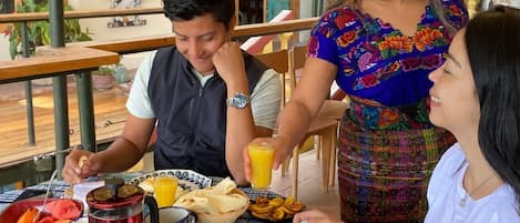 A dining table with breakfast items, a coffee pot, and a pitcher of orange juice.