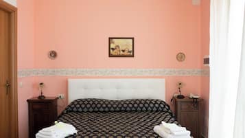 A bedroom with a bed, two nightstands, a painting on the wall, and a door.