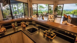 A modern kitchen with a large island, a sink, and a tea set.