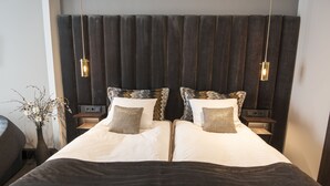 A double bed with a dark headboard and two bedside tables, each with a lamp. - B14 Luxury Penthouse down town for groups (Reykjavík)