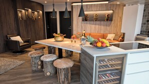 A modern kitchen with a central island, wooden stools, and a wine cooler. - B14 Luxury Penthouse down town for groups (Reykjavík)