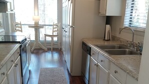 A kitchen with white cabinets, a granite countertop, a built-in dishwasher, and a window with blinds. - 4 Bed/2 bath- sleeps 9, club cards avail, Golf cart, pets ok, neighborhood pool (St Helena Island)