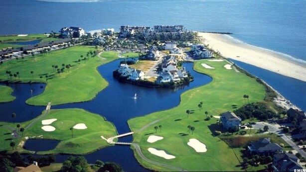 An aerial view of a coastal golf resort with multiple buildings, a sandy beach, and water bodies. - 4 Bed/2 bath- sleeps 9, club cards avail, Golf cart, pets ok, neighborhood pool (St Helena Island)