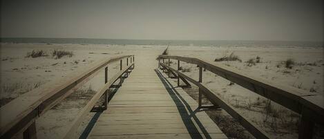 A wooden boardwalk leading to the beach.
