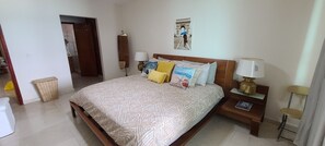 A neatly arranged bedroom with a bed, bedside lamps, a nightstand, and a wall-mounted mirror. - Amazing Beach Front Apartment, 3 BDRMS, 3 Baths, Sleeps 8, (Cancun)