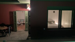 Una habitación con cama, ventana y puerta que da a otra estancia.