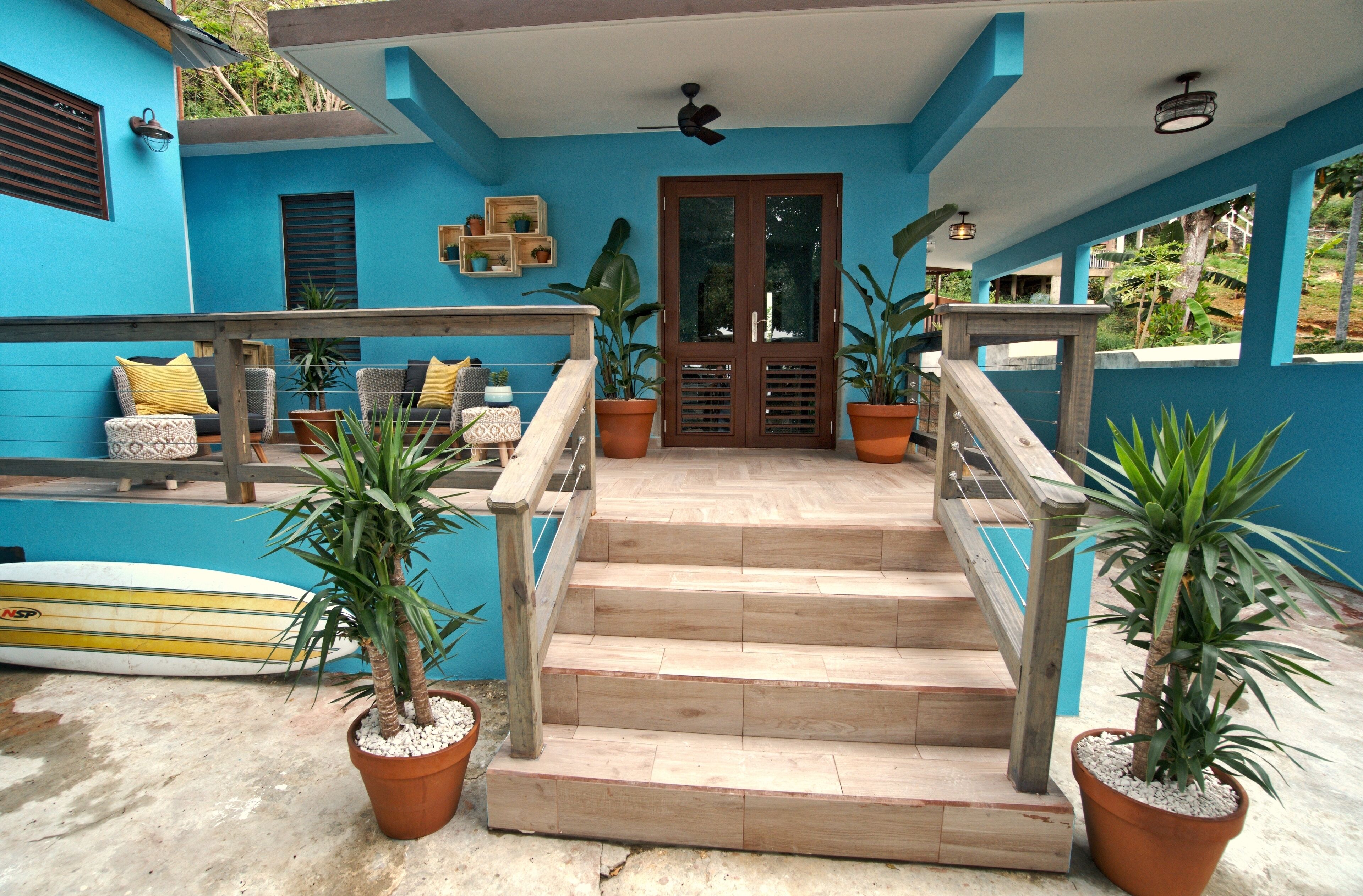 A staircase leading to a door with a blue exterior and wooden railings.