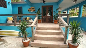 A staircase leading to a door with a blue exterior and wooden railings.