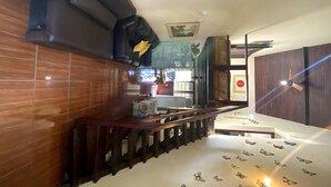 Una escalera con barandilla de madera que lleva a una habitación con cama, escritorio y ventana.