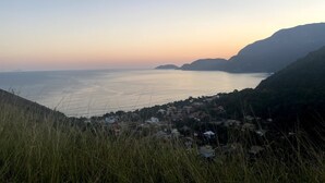 Un pueblo costero con casas a lo largo de la ladera, con vistas a un mar tranquilo.