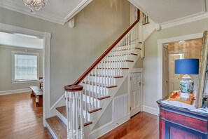 A staircase with white railings and wooden steps, leading to a landing with a bench and a lamp. - Huge Historic 4BR House w/  Patio, sleeps 12 (Jackson)