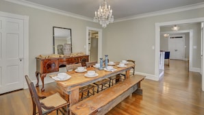 A dining room with a wooden table set for six, a chandelier, and a mirror on the wall. - Huge Historic 4BR House w/  Patio, sleeps 12 (Jackson)