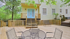 A wooden deck with outdoor seating and a blue door leading to a porch. - Huge Historic 4BR House w/  Patio, sleeps 12 (Jackson)