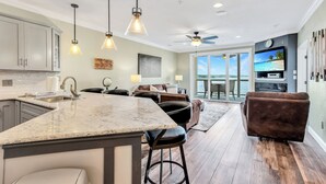 A modern kitchen with a large island, bar stools, and pendant lighting. - View for Miles! Remodeled Lands' End Luxury Condo - Wifi, Waterpark, Pool, Docks (Osage Beach)