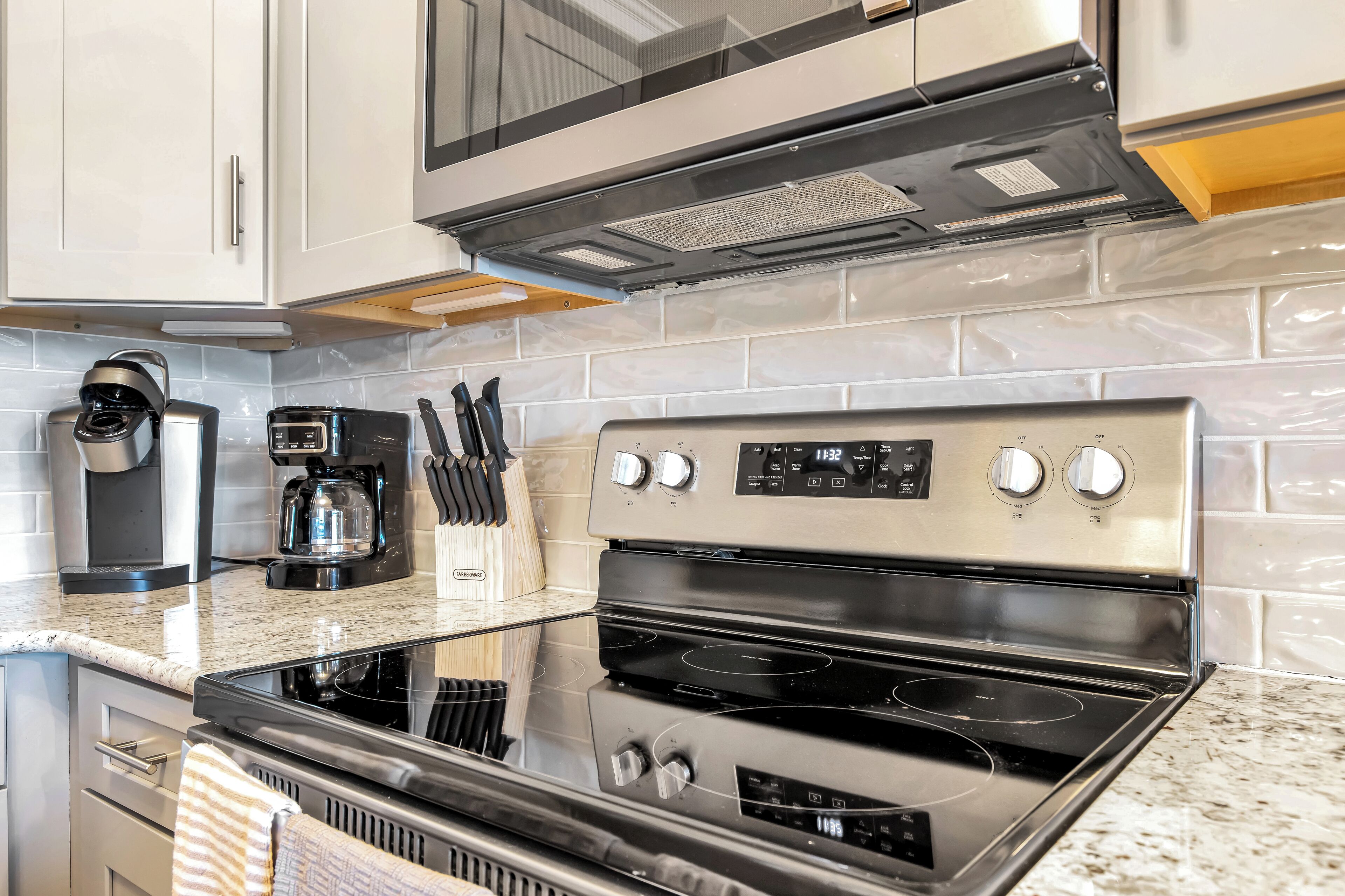 A modern kitchen with stainless steel appliances, including a microwave, coffee maker, and stove.