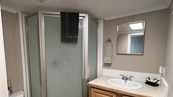 Ein Badezimmer mit Dusche, Toilette und Waschtisch.