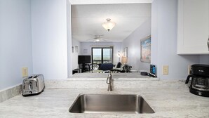 A modern kitchen with a stainless steel sink, a toaster, and a coffee maker. - St. Augustine Oceanfront Rental – Pools, Balcony & Beach Access (St. Augustine)