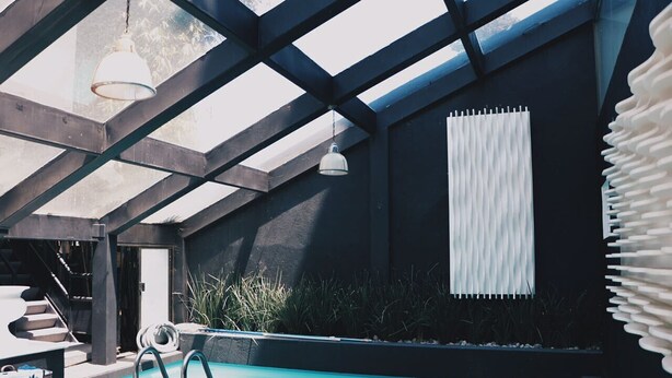 Ein moderner, überdachter Poolbereich mit Pool und einer Treppe zu einer erhöhten Ebene.