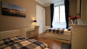 A bedroom with two beds, a desk, a chair, a window with curtains, and a painting on the wall. - 3 bedrooms Premium Apartment - La Suite Lanterne (Lyon)