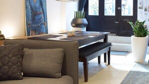 Un salon moderne avec un canapé, une table à manger et un grand tableau accroché au mur.