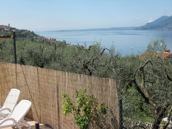 A terrace with a view of a lake and distant buildings.