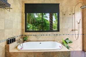 Een bad/douchecombinatie, een haardroger, handdoeken, zeep