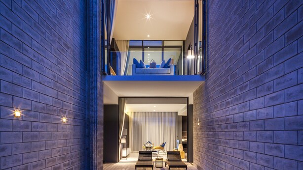 A modern building with a glass balcony, a pool, and a seating area. - Oceanphere Pattaya Villa (Sattahip)