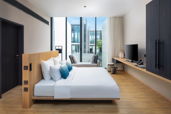 Ein modernes Hotelzimmer mit einem großen Bett, einem Fernseher und einem Balkon mit Blick auf die Stadt.