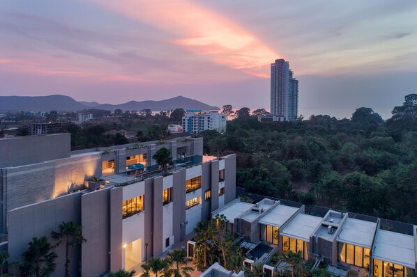 A modern building complex with multiple residential units, surrounded by greenery and a mountain in the background. - Oceanphere Pattaya Villa (Sattahip)