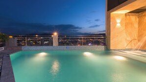 A rooftop pool with a city view at dusk. - Zenia Boutique Hotel Nha Trang (Nha Trang)