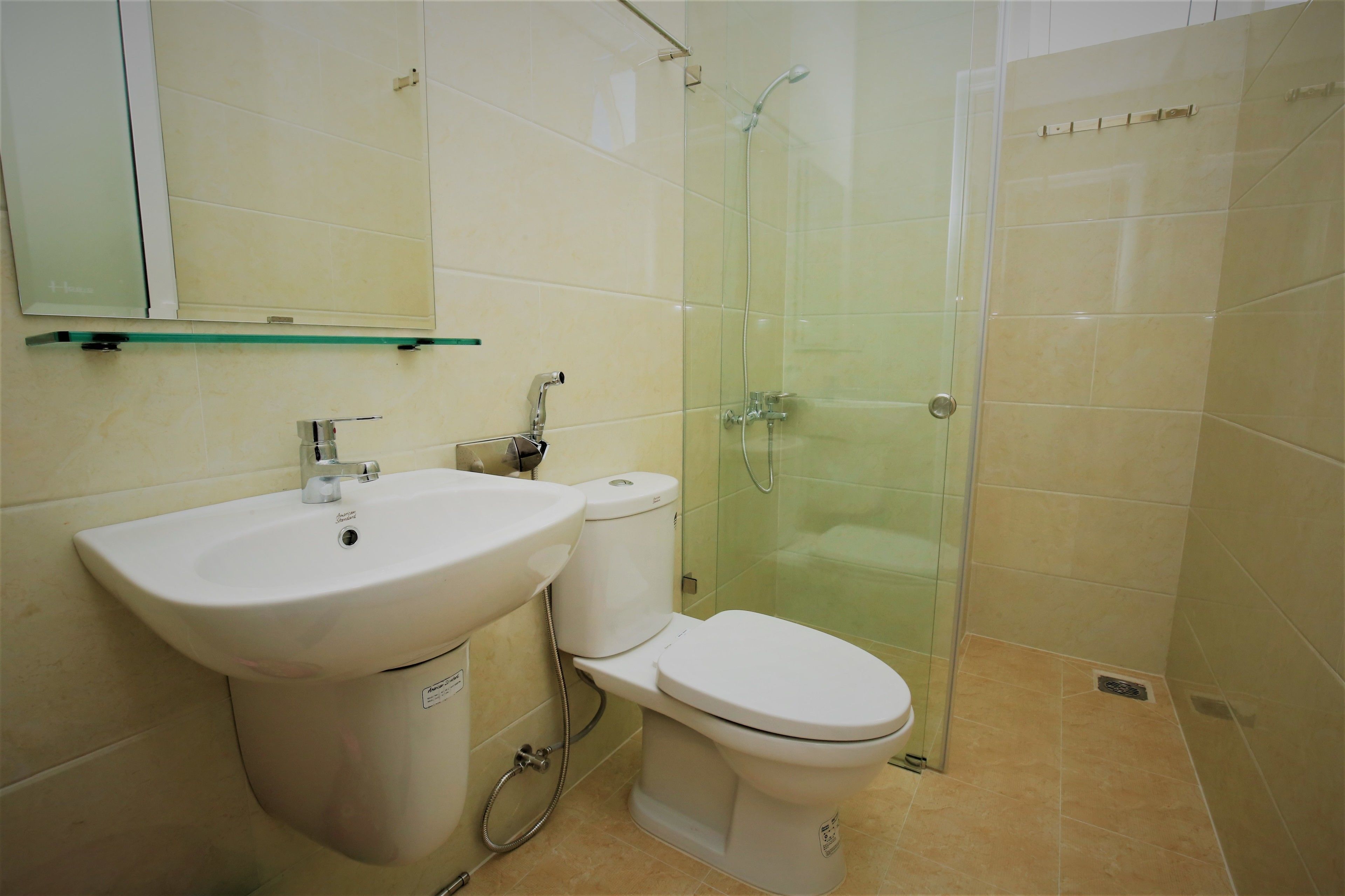 Un baño con lavabo, inodoro y cabina de ducha de vidrio.