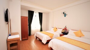A hotel room with two beds, a wooden nightstand, a TV, and a window with curtains. - Da Lat Phu Tho Hotel (Xuan Huong - Da Lat)