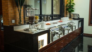A modern hotel breakfast area with a buffet setup, including glass containers and a coffee machine. - Hotel de la Renaissance (Siem Reap)