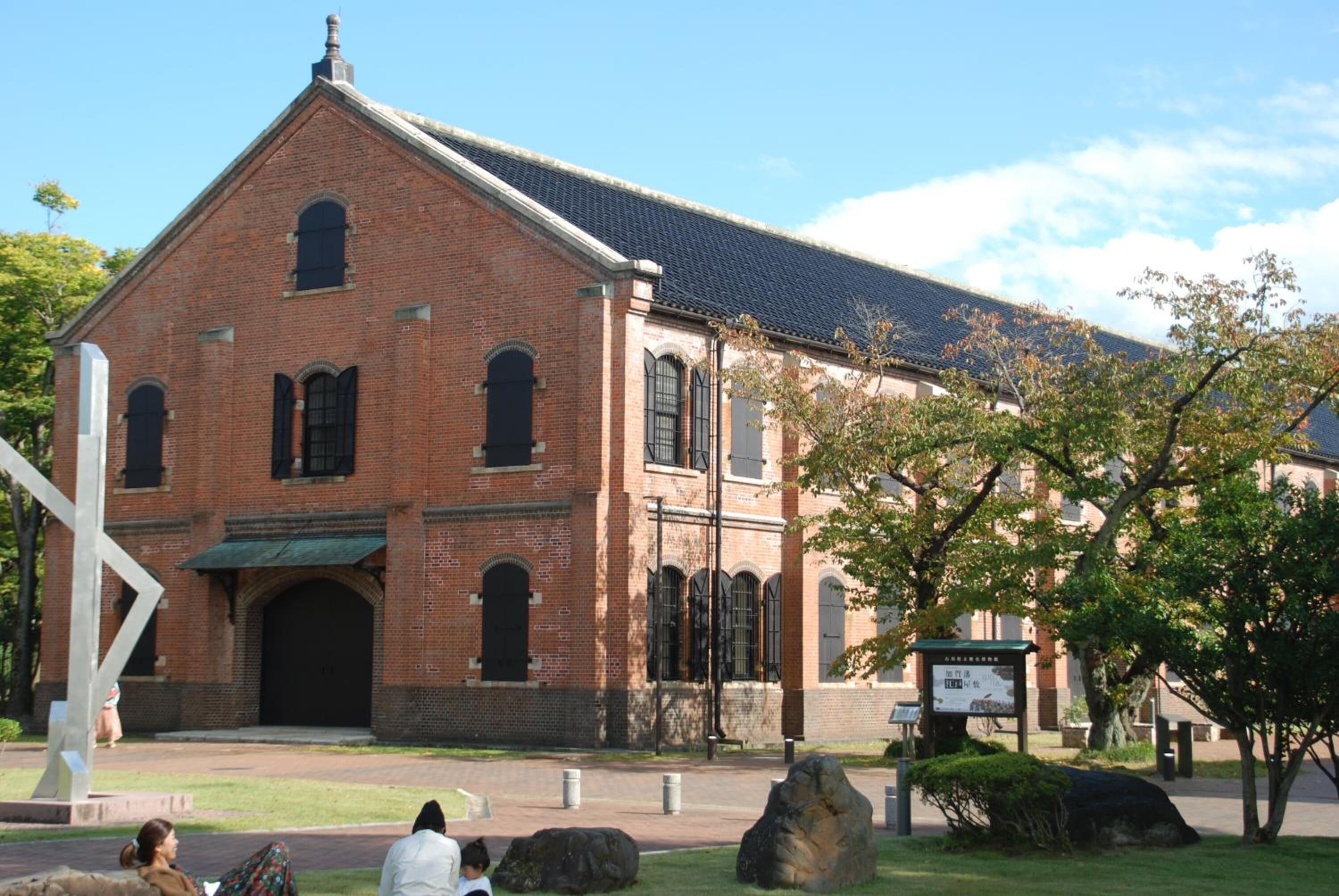 A brick building with a large arched entrance and a sloped roof.