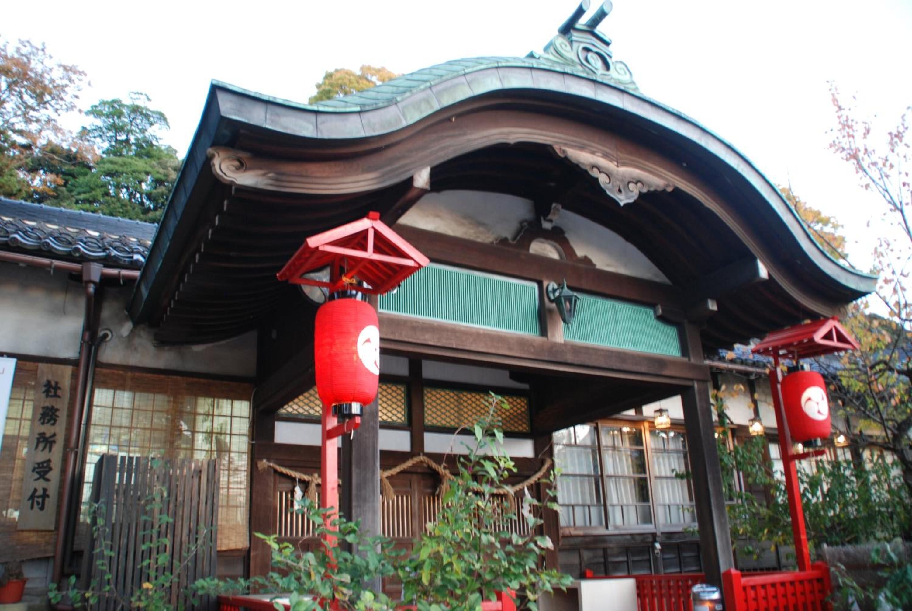 Un edifici tradicional japonès amb un teulat corbat i fanals vermells.