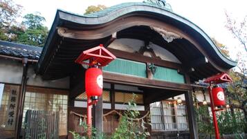 Un edifici tradicional japonès amb un teulat corbat i fanals vermells.