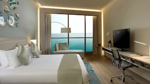 A hotel room with a bed, a desk, a television, and a large window with a view of the sea. - Royal M Hotel Abu Dhabi by Gewan (Abu Dhabi)