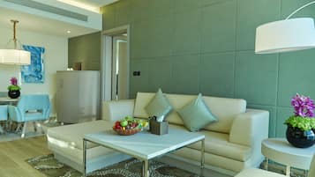 A modern living room with a sofa, coffee table, and a dining area with chairs and a table.