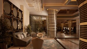 A modern lobby with a sofa, armchairs, a coffee table, and a potted plant. - Royal M Hotel Abu Dhabi by Gewan (Abu Dhabi)